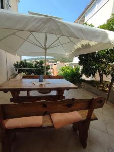 a wooden table with an umbrella on a patio at Apartments Laus in Zavalatica
