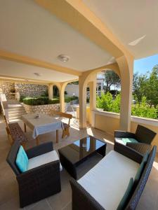 a living room with chairs and a table at Apartments Villa Jagoda in Rab