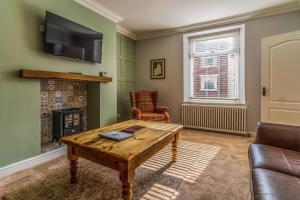 a living room with a coffee table and a fireplace at Ebenezer House in Newbiggin-by-the-Sea