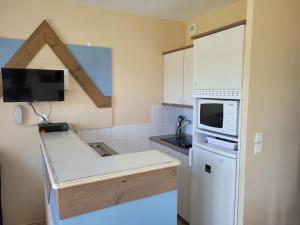 a kitchen with a white refrigerator and a microwave at Village Belle Dune Fort-Mahon plage in Fort-Mahon-Plage