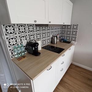 a kitchen with white cabinets and a counter top at Apartament na Starówce in Elblag