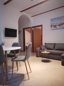 ein Wohnzimmer mit einem Tisch und einem Sofa in der Unterkunft Apartments Villa Jagoda in Rab