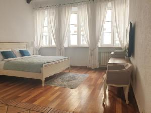 een slaapkamer met een bed, een stoel en ramen bij Old Town Essence Apartment in Warschau