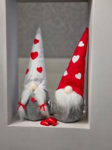 two stuffed animals wearing red and white hats on a shelf at b&b dolce casa con Sauna e cromoterapia in Domodossola +18 photos