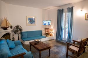 スーニオにあるAndrew's House Punta Zezaのリビングルーム(青いソファ、テーブル付)