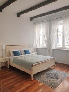 een witte slaapkamer met een groot bed met blauwe kussens bij Old Town Essence Apartment in Warschau
