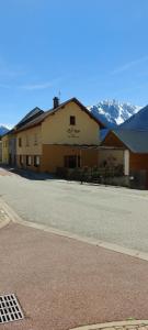 a building on the side of a street with a mountain at Chambre d'hotes le cycliste in La Chapelle