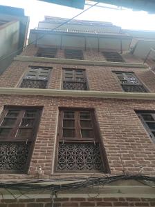 a tall brick building with four windows on it at Awale House in Pātan