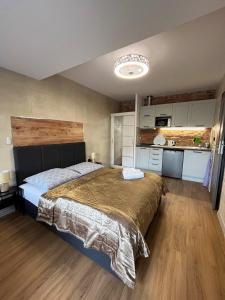 a bedroom with a large bed and a kitchen at Kasia&Tomek in Darłówko
