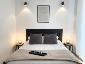 1 Schlafzimmer mit einem Bett mit einem schwarzen Kopfteil und 2 Tischen in der Unterkunft LES HALLES 2 - Central in Mont-de-Marsan