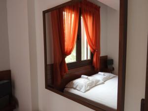 a mirror reflection of a bed with a window at Konstantinos' Nikiti Apartment in Nikiti