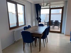 ein Esszimmer mit einem Holztisch und blauen Stühlen in der Unterkunft Private villa in Yalova/Thermal, with heated pool in Termal