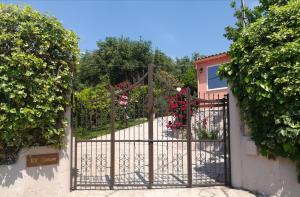 a gate to a garden with flowers and roses at EY House in Halikounas