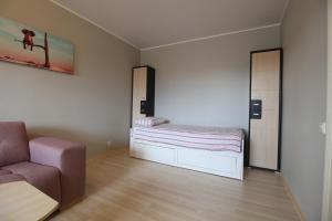una piccola camera con letto e sedia di Magistral Contact Free Apartment with free parking a Tallinn