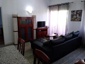 a living room with a black couch and a table at Apartamento Balsa in Viseu