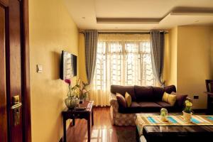 uma sala de estar com um sofá e uma janela em The Cottage Residence Karen em Nairobi