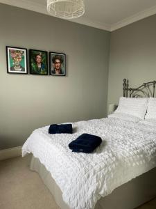 a bedroom with a white bed with pictures on the wall at Period two-bed house, next to river and city in York