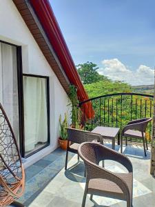 Un patio con sillas y una mesa en el balcón. en El Castillo Bed and Breakfast en Angono