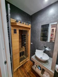 a bathroom with a sink and a glass shower at b&b dolce casa con Sauna e cromoterapia in Domodossola