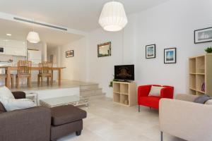 a living room with a couch and a red chair at VILLA MANAVA in Llafranc