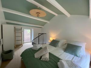 a bedroom with a large white bed with green sheets at La ferme de Valfons in Sauve