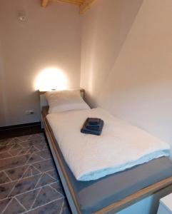 a bed in a room with a light on it at Watt´n Blick - Hundefreundliches Ferienhaus mit Ausblick über die Wiesen bis zum Deich in Schweiburg