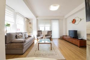 een woonkamer met een bank en een salontafel bij RUPE Apartments - FREE PARKING in city center! in Ohrid