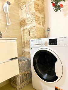 a washer and dryer in a kitchen with a wall at Corte Merlata Apartments in Galatone