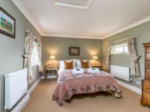 a bedroom with a large bed and two windows at Pass the Keys Charming Country Cottage With Spectacular Views in Chichester