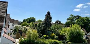 沃靈頓的住宿－Beddington Park Lodge East，享有带树木和房屋的庭院的景色