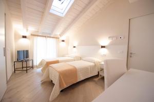 マリーナ・ディ・カッラーラにあるVillino Micol camere a due passi dal mareのベッド3台とテレビが備わる客室です。