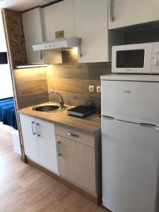 a kitchen with a white refrigerator and a sink at Vistas al mar 4 Canabal in A Coruña