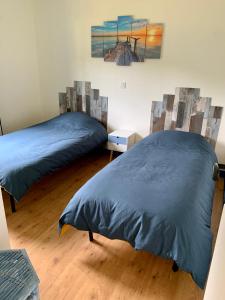 1 dormitorio con 2 camas y un cuadro en la pared en Le clos rozan, en Sainte-Eulalie-en-Born