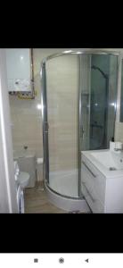 uma casa de banho com um chuveiro e um lavatório branco em Apartament w sercu Ciechocinka em Ciechocinek