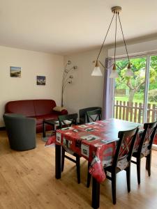 sala de estar con mesa, sillas y sofá en Le clos rozan, en Sainte-Eulalie-en-Born