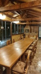 a large wooden table and chairs in a room with windows at Pensiunea Antonio Bran in Bran