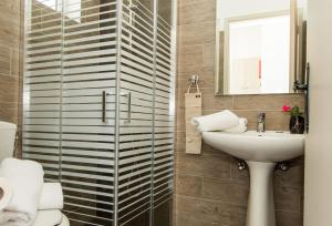 a bathroom with a sink and a toilet and a mirror at Kolevri Studios in Laganas