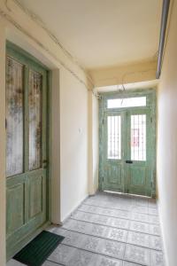 an empty room with a green door and a tile floor at TAMO Rooms in Tbilisi City