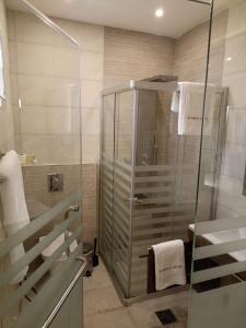 uma casa de banho com um chuveiro e uma cabina de duche em vidro. em AlQimah Hotel Apartments em Amã