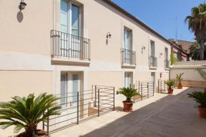 un edificio con balcones y plantas en un patio en Boutique Hotel Molo S Lucia en Siracusa