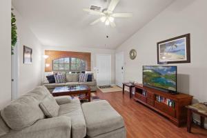 a living room with a couch and a flat screen tv at Family vacation, heated pool, wake up to enjoy the sunrise - Villa Pine Island in Cape Coral