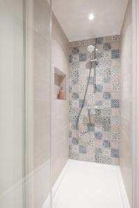 a shower with a glass door in a bathroom at Le Maetica - 5 min de Disneyland Paris in Coupvray