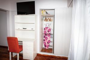 a white closet with a pink snowboard on a shelf at Palermo 2 in Buenos Aires