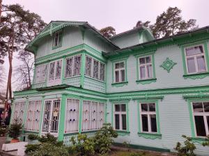 Una gran casa verde y blanca con ventanas en Hotel Marino en Jūrmala