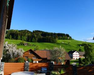 a view of a house with a hill in the background at Ferienwohnung Eisenring in idyllischer Umgebung in Gähwil