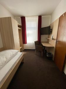 a hotel room with a bed and a desk at Hotel Alt Westerholt in Herten