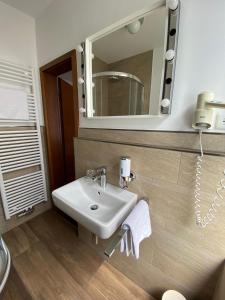 W łazience znajduje się umywalka i lustro. w obiekcie Hotel Alt Westerholt w mieście Herten