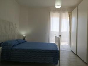 a bedroom with a blue bed and a window at CM HOUSE MARZAMEMI in Marzamemi