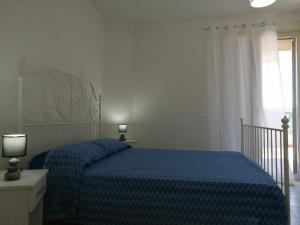 マルツァメミにあるCM HOUSE MARZAMEMIのベッドルーム(青いベッド1台、窓付)