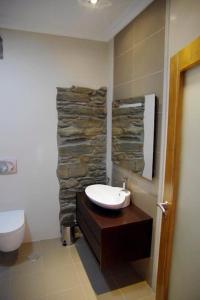 a bathroom with a sink and a stone wall at Casa restaurante O Pitès in Alfaião +34 photos